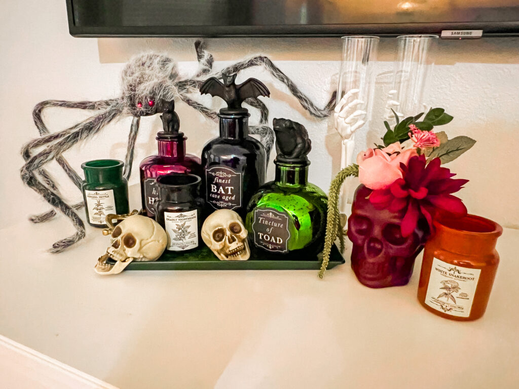 Tray of potions with a hovering and protective giant hairy spider.